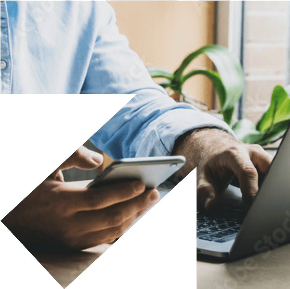 Man holding phone while using mac